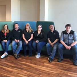 Employee Jeans Days PREMIER Employees sitting on couch in bank building
