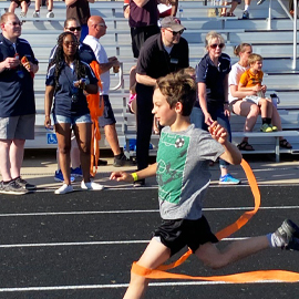 Track & Field Meets Child running in a track meet with cheering fans