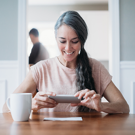 Extra Benefits woman depositing check with mobile phone