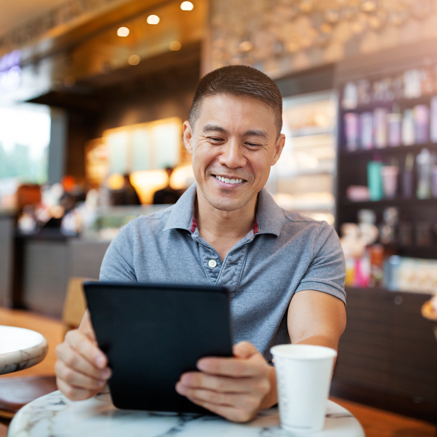 Credit Score and More Man in coffee shop looking at tablet