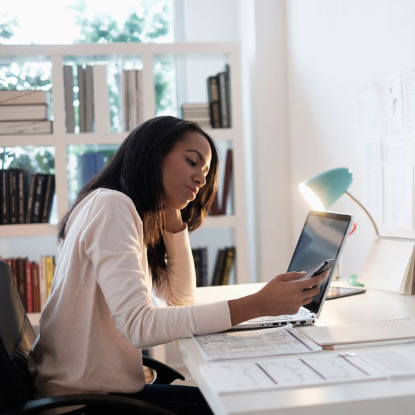 Password Best Practices Woman sitting at desk working on laptop